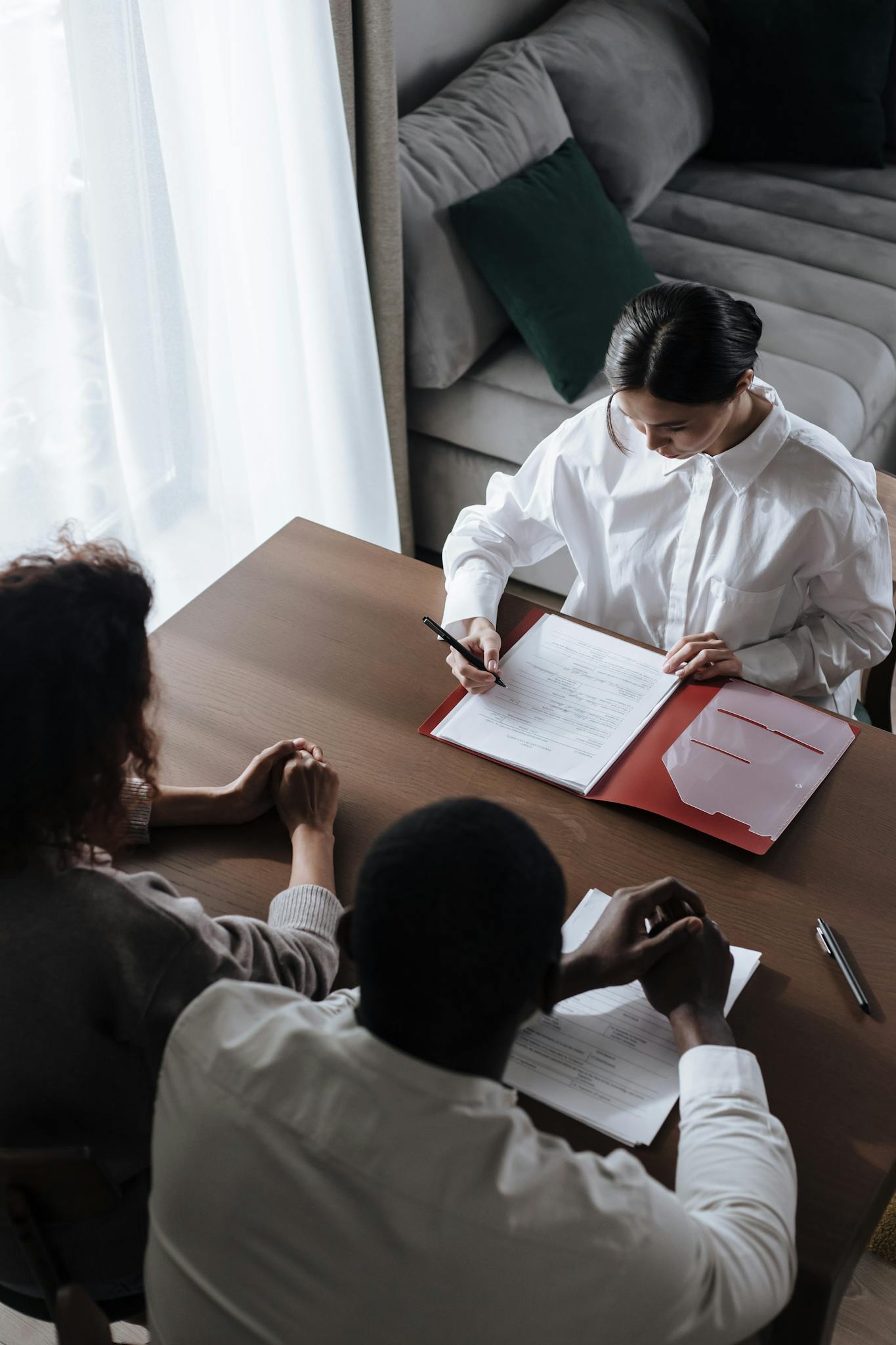Business professionals in a meeting reviewing documents at a table.